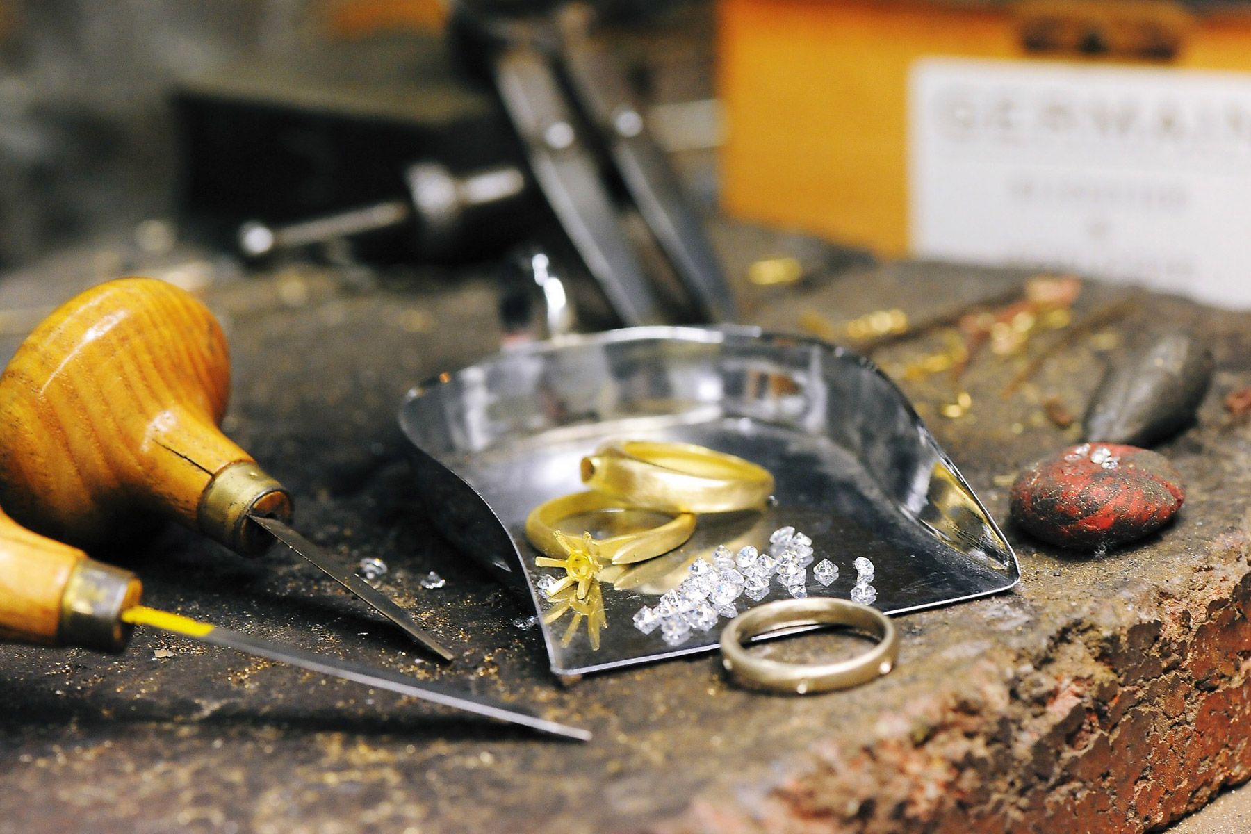 Photo d'outils de bijoutier artisanal avec diamants et anneaux en or